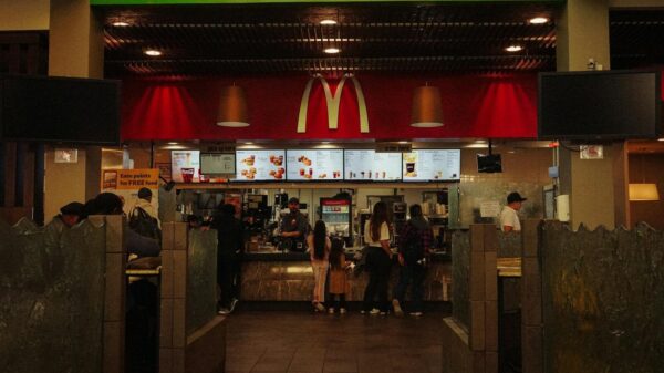 A bustling scene at a McDonald's restaurant counter with customers and staff in an indoor setting.