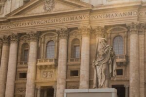 The majestic facade of St. Peter's Basilica in Vatican City featuring a prominent statue.