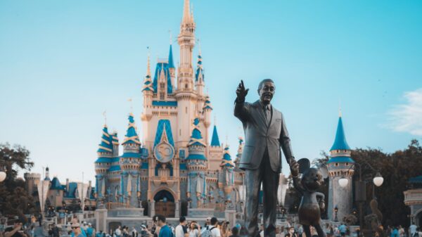 View of the iconic Cinderella Castle at Walt Disney World in Orlando, Florida, with crowd and statue.