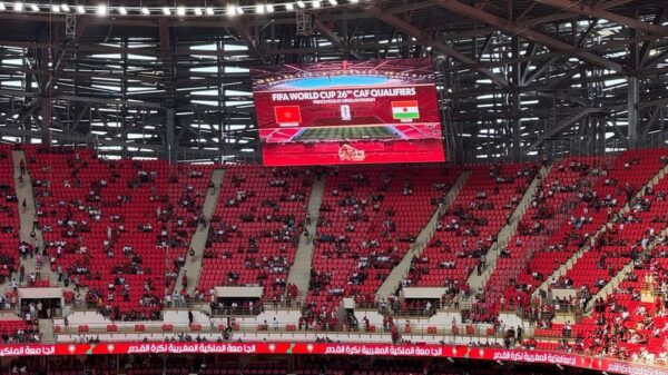 A bustling stadium during the FIFA World Cup CAF Qualifiers, showcasing vibrant crowds and electric atmosphere.
