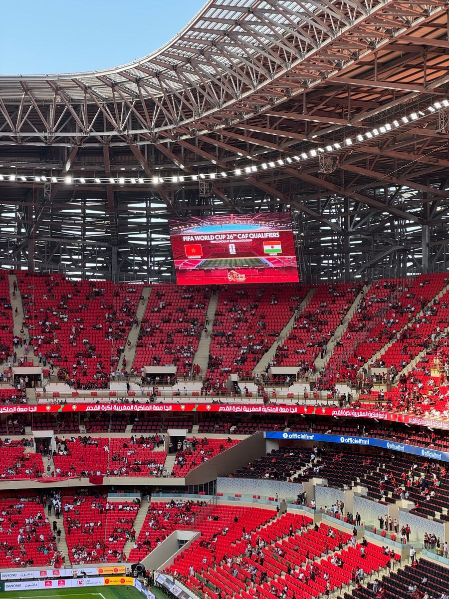 A bustling stadium during the FIFA World Cup CAF Qualifiers, showcasing vibrant crowds and electric atmosphere.