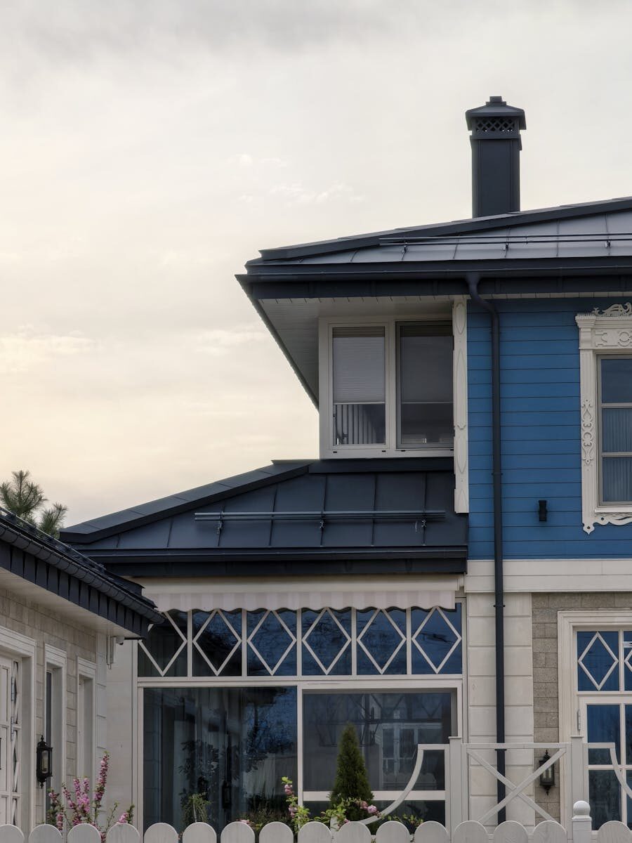 A stylish blue house featuring unique geometric windows, showcasing modern architecture.