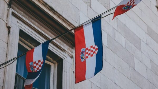 Flags of Croatia on a historic building facade, perfect for cultural and architectural themes.