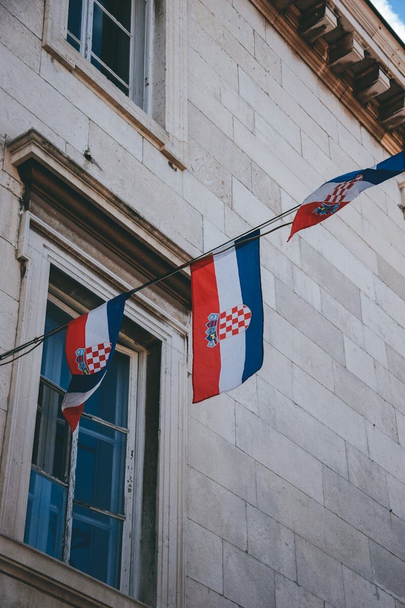 Flags of Croatia on a historic building facade, perfect for cultural and architectural themes.