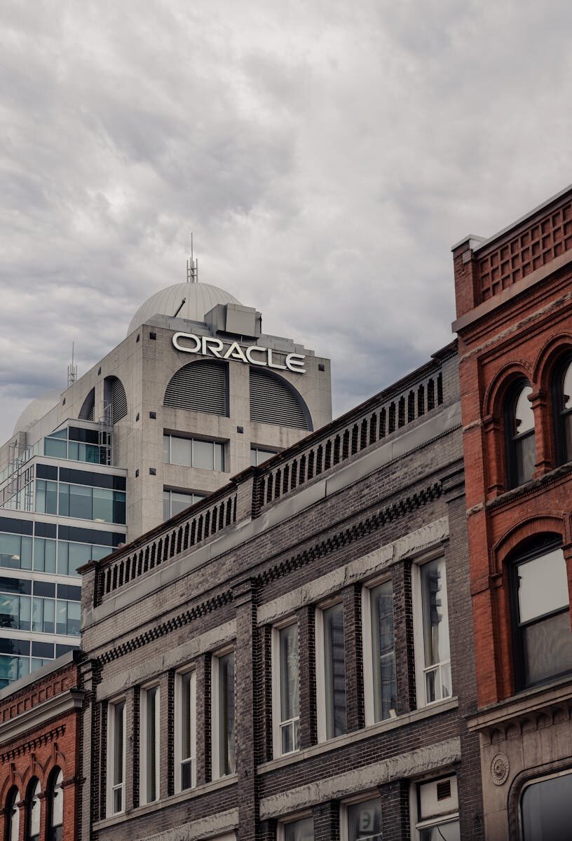 Cityscape with Oracle building in Kitchener, showcasing diverse architectural styles under an overcast sky.
