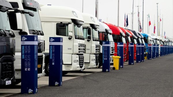 Line of racing trucks with bollards at event in Estoril, Portugal.