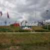 Large Belgrade sign in a park setting with flags on a cloudy day, Serbia