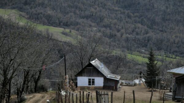 Tranquil rural village with wooden houses in a mountain landscape.