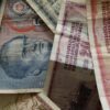 A close-up photo of diverse vintage banknotes, showcasing historical currency from different countries.