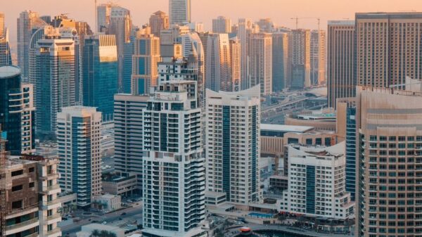 Aerial view of Dubai Marina with skyscrapers at sunset reflecting in the water.