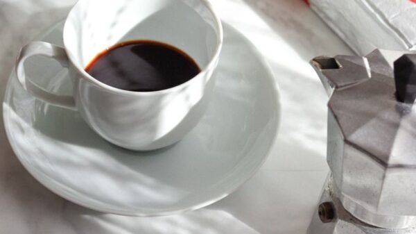 Elegant coffee scene with Lavazza packaging and floral decor on a marble tabletop.