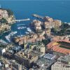 Scenic aerial view of Monaco's coastal cityscape with harbors and Mediterranean Sea.