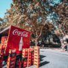 Coca-Cola truck unloading crates on a sunny street in Seville, Spain.