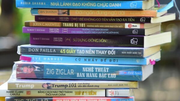 A colorful pile of self-help and business books arranged outdoors, showcasing various titles and themes.