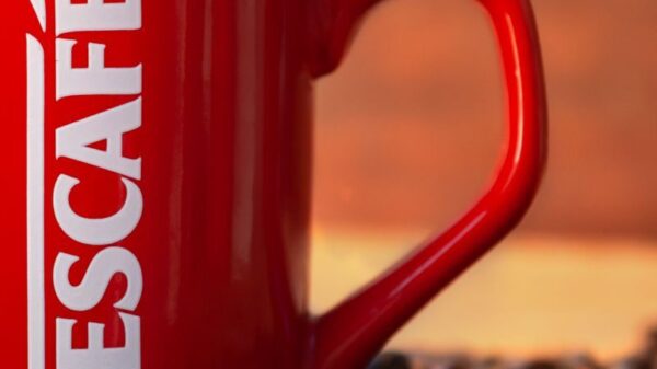 Red mug surrounded by coffee beans creates a cozy and inviting atmosphere.
