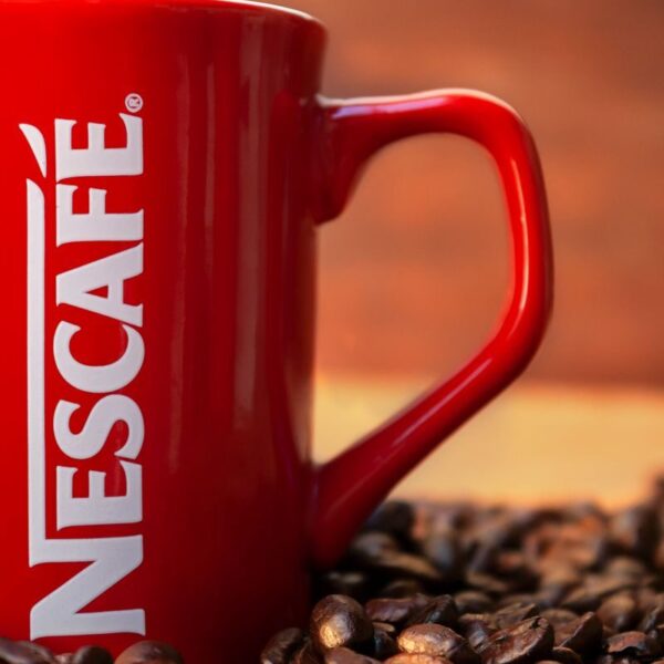 Red mug surrounded by coffee beans creates a cozy and inviting atmosphere.