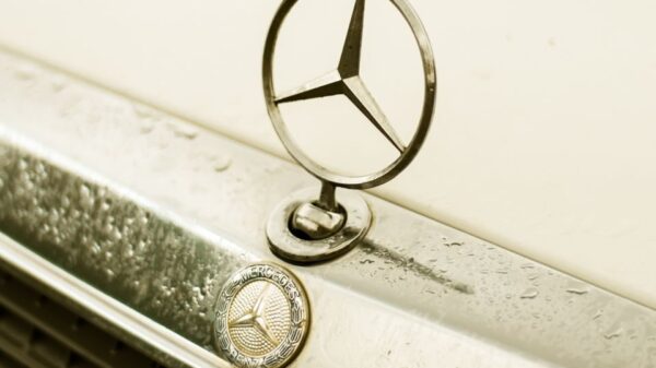 A detailed shot of a classic Mercedes-Benz emblem on a vintage car.