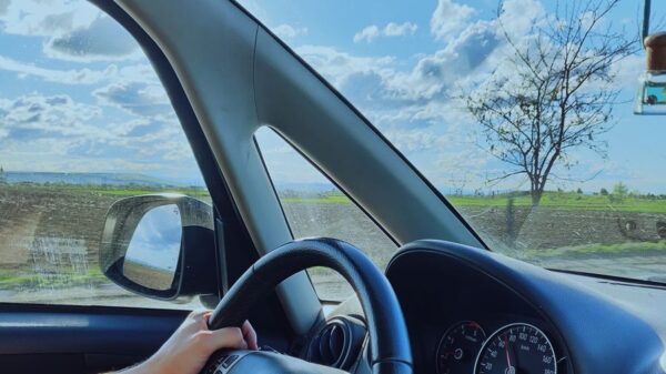 View from inside a car showcasing a scenic drive with blue skies and an open road.