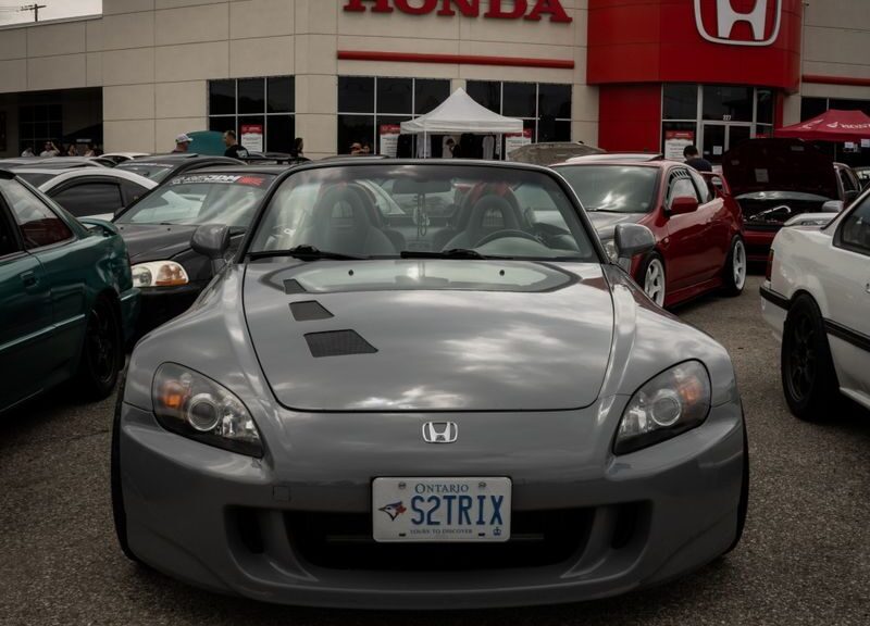 Honda dealership showcasing a sleek parked car on a cloudy day.