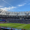 A packed London Stadium hosts a thrilling soccer match, with vibrant atmosphere and engaged crowd.