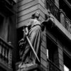 A dramatic black and white photo of a justice statue holding a sword and scales.