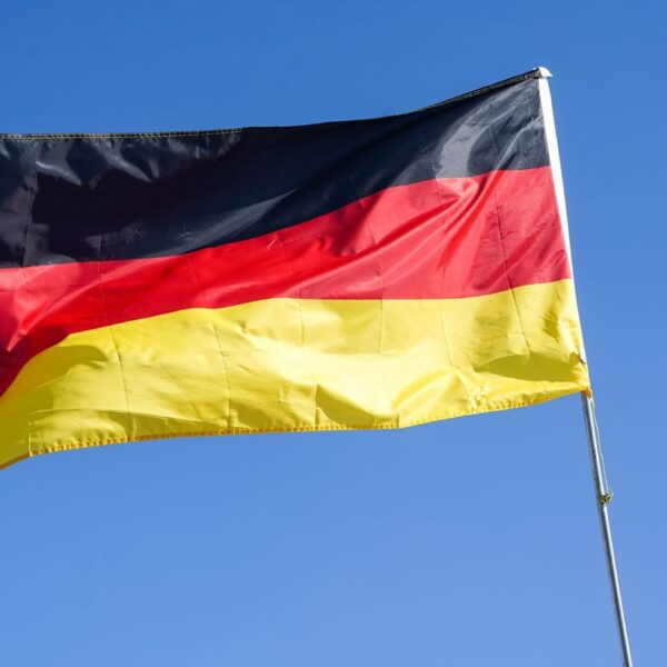 German national flag waving prominently against a bright blue sky in Lüneburg, Germany.