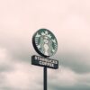 A Starbucks Coffee sign with a cloudy sky backdrop in Brazil, creating a moody ambiance.