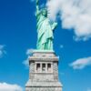 Iconic Statue of Liberty shot with a dramatic low angle against a clear blue sky, perfect for travel and tourism themes.