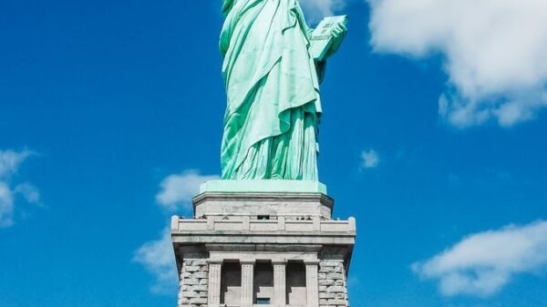 Iconic Statue of Liberty shot with a dramatic low angle against a clear blue sky, perfect for travel and tourism themes.