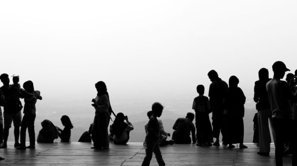 Monochrome silhouettes of people socializing on a scenic observation platform.