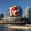 A massive soccer ball decorates Science World, set against Vancouver's iconic skyline and waterscape.