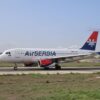 Air Serbia Airbus A320 on the runway ready for takeoff on a clear day.