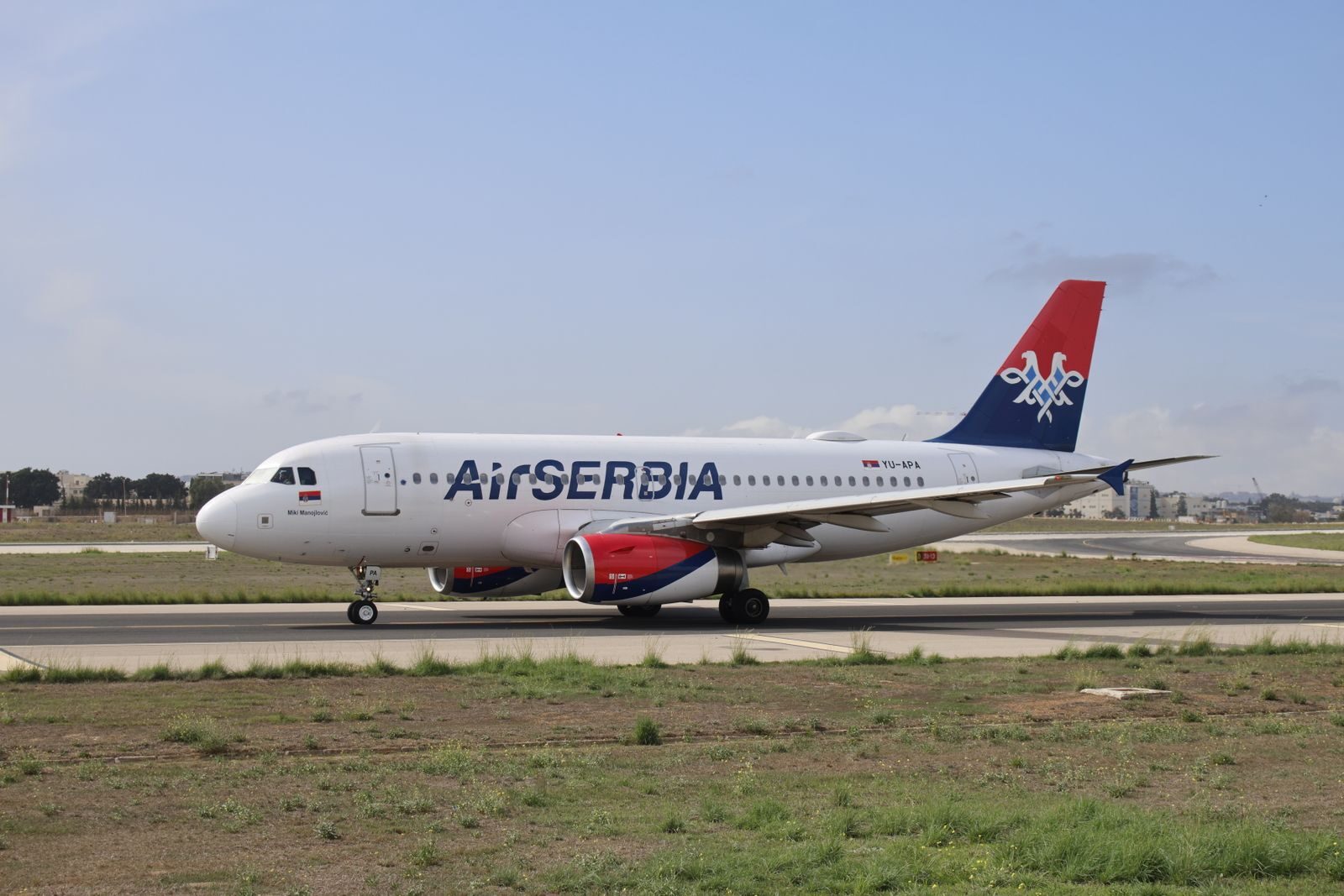 Air Serbia Airbus A320 on the runway ready for takeoff on a clear day.