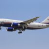 Airplane flying in clear blue sky with Canadian government livery.