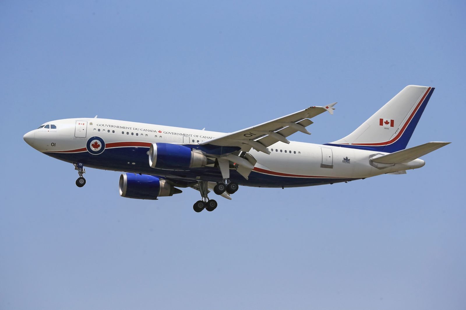 Airplane flying in clear blue sky with Canadian government livery.