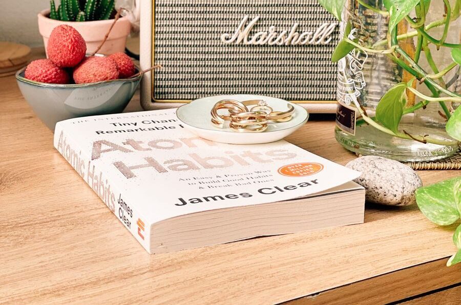A book, fruits, and a vintage speaker on a cozy table setting indoors.