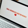 Close-up of laptop displaying 'Small Businesses Have Big Hearts' message with a heart icon.
