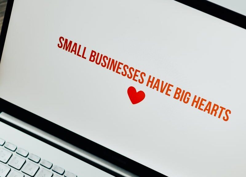 Close-up of laptop displaying 'Small Businesses Have Big Hearts' message with a heart icon.