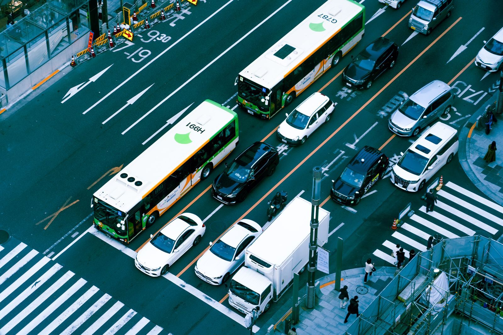 Aerial photograph capturing a busy city intersection filled with buses and cars, showcasing urban traffic.