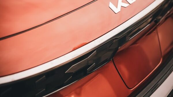 Stylish close-up of a red Kia vehicle's rear, showcasing the new logo design.