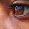 Detailed close-up of a brown eye reflecting a scene, showcasing texture and color.