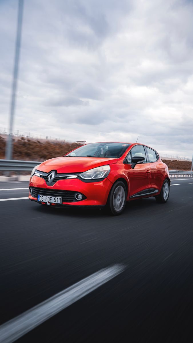 Dynamic shot of a red Renault Clio driving on a highway in Ankara, Türkiye.