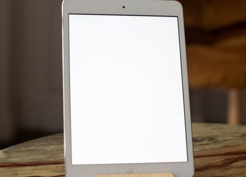 A contemporary tablet stands vertically on a marble table, perfect for mockup use.