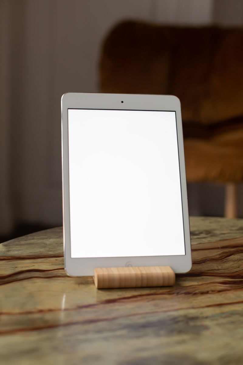 A contemporary tablet stands vertically on a marble table, perfect for mockup use.