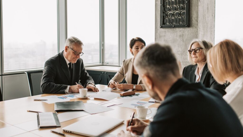 Business professionals engaged in a collaborative meeting around a conference table.