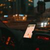 Car dashboard with GPS showing map on a digital screen during city driving at dusk.