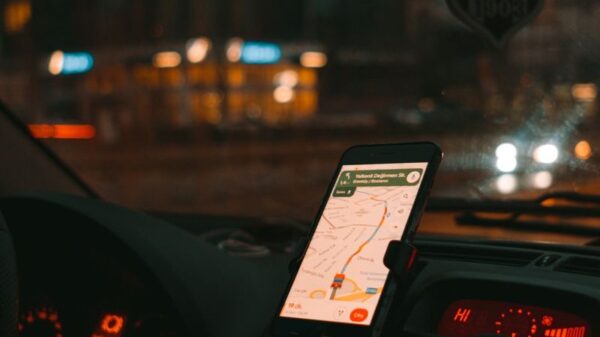 Car dashboard with GPS showing map on a digital screen during city driving at dusk.