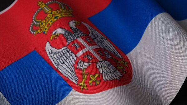 Close-up of the Serbian national flag showcasing its emblem and colors, symbolizing pride.