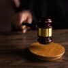 A gavel striking a sound block, symbolizing justice and legal authority in a courtroom setting.