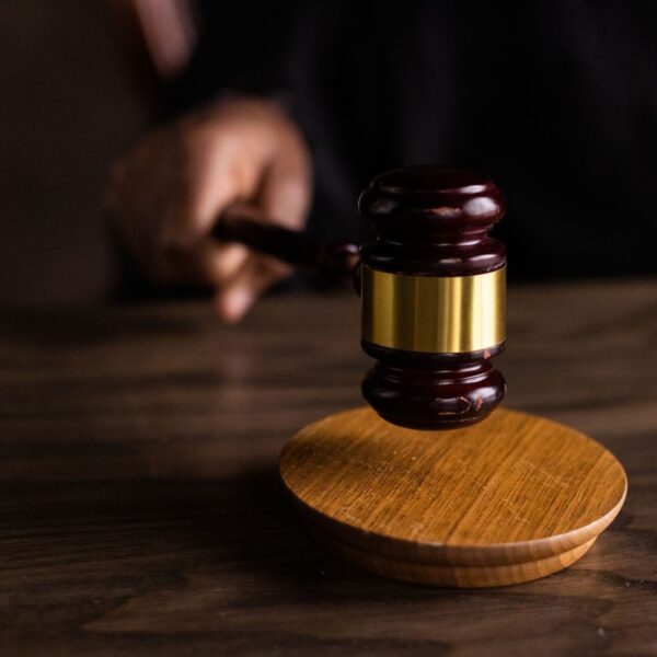A gavel striking a sound block, symbolizing justice and legal authority in a courtroom setting.